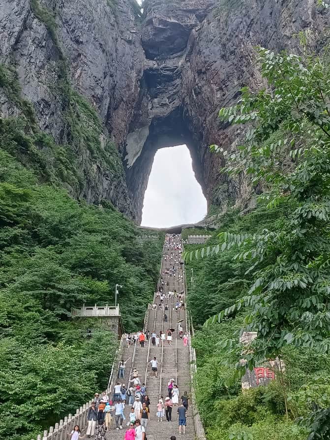 ALT:天门山索道穿越壮丽山峰,游客欣赏自然奇观。.