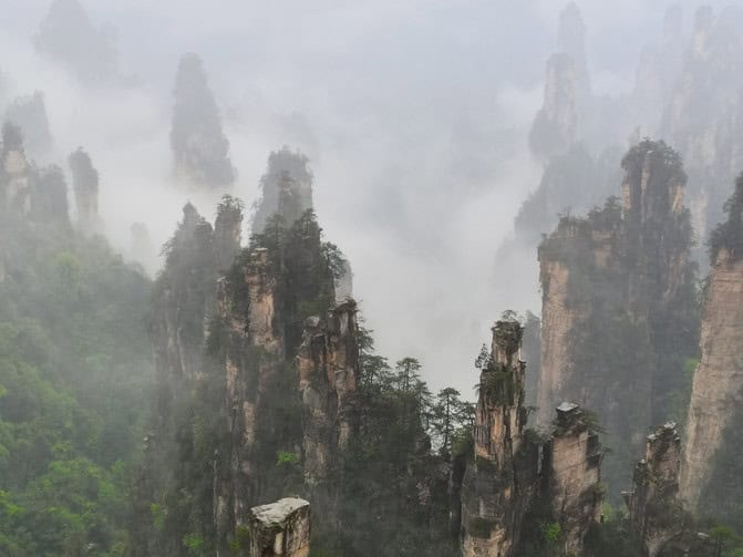 张家界国家森林公园的奇峰在云雾中若隐若现,展现壮丽的自然景观。.